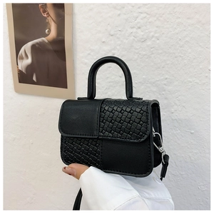Gros plan du mini sac à bandoulière noir avec design patchwork et panneaux tressés