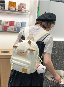 Detailansicht eines weißen Rucksacks in Schaf-Optik mit 3D-Ohren und Plüsch-Anhänger
