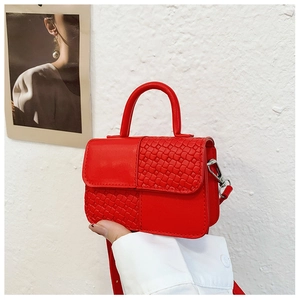 Détail du mini sac rouge montrant le similicuir lisse et le patchwork de texture tissée