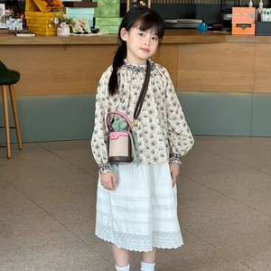 Girl's vintage floral top and white lace skirt with a pink mini chain bucket bag
