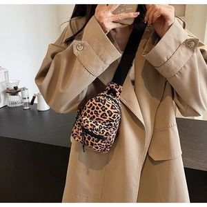 Close-up of leopard print chest bag with black zippers on a model in beige trench coat