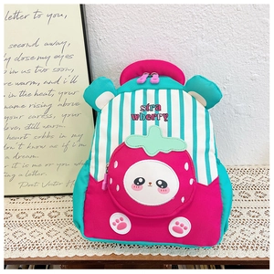 Close-up of children backpack featuring a cartoon strawberry pocket and striped canvas detail