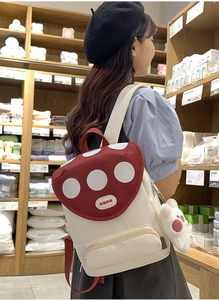 Detailed view of mushroom backpack with red polka dot flap and cute rabbit charm