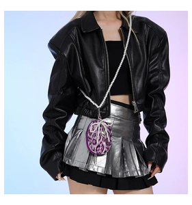 Detail of purple leopard print mini bag with pearl chain and bow on leather jacket