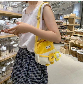 Détail du sac bandoulière canard avec breloque tournesol et sangle jaune ajustable