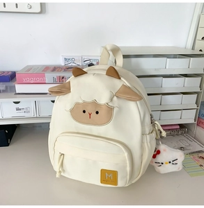 Detail des weißen Lamm-Rucksacks mit 3D-Ohren und einem niedlichen Katzen-Plüschanhänger