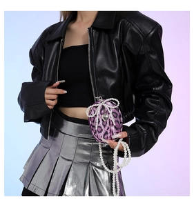 Detail of purple leopard print mini bag with pearl bow and silver heart pendant charm