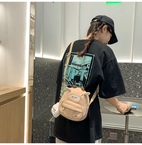 Gros plan d'un sac bandoulière mouton beige avec oreilles 3D et poche avant zippée