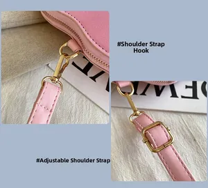 Detail of pink leather shoulder bag featuring gold metal hooks and adjustable strap
