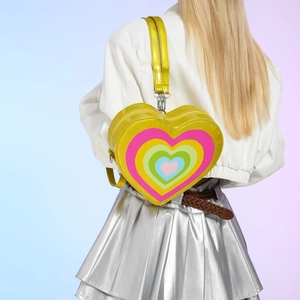 Yellow heart-shaped crossbody bag with rainbow heart pattern shown on model back