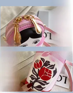 Detail of pink cartoon doll crossbody bag featuring smooth golden double zippers