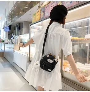 Détail du petit sac à bandoulière vache noir avec breloque en peluche et broderie