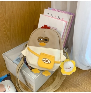 Détail du sac à bandoulière poussin mignon avec pendentif tournesol et poche smile brodée