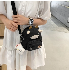 Détail du sac à bandoulière mouton noir avec breloque Hello Kitty et sangle réglable
