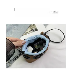 Vue de dessus d'un sac seau en daim marron avec cosmétiques et doublure à cordon serrage