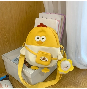 Détail du sac bandoulière poussin mignon avec pendentif fleur en peluche et sangle jaune