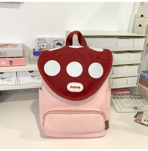 Close-up of cute pink and red polka dot backpack with front zipper pocket and nana logo