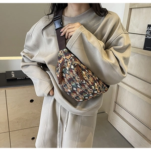Detail of bohemian chest bag featuring multi-colored geometric knit pattern and wide strap