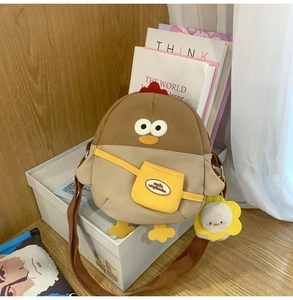 Détail du sac bandoulière poussin avec pendentif canard en peluche et sangle en tissu