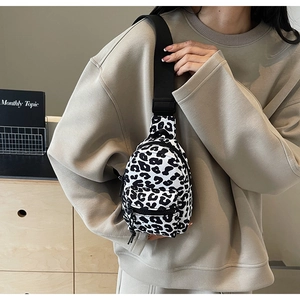 Close-up of black and white leopard print mini crossbody bag with wide shoulder strap