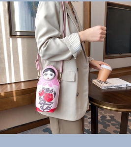 Detailed view of pink Russian doll shaped crossbody bag with floral pattern and zipper