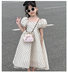 Détail du sac à main rose avec nœud et robe en coton à pois blancs pour filles