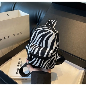 Detailed macro view of zebra pattern mini backpack inside a stylish gift box