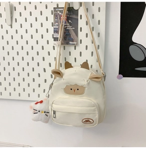 Détail du sac bandoulière mouton blanc avec oreilles en cuir et breloque en peluche