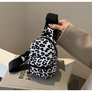 Detail of a mini leopard print chest bag with adjustable strap and zip pockets