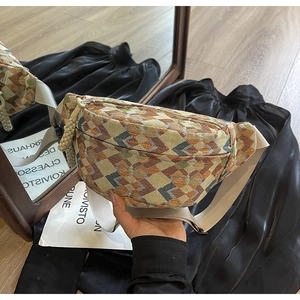 Detail view of ethnic jacquard fanny pack with colorful patterns and woven knot decoration