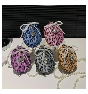 Detailed macro view of five leopard print mini bags with pearl bows and heart charms
