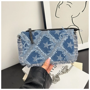 Close-up of denim shoulder bag featuring a frayed star patch and long fringe tassels