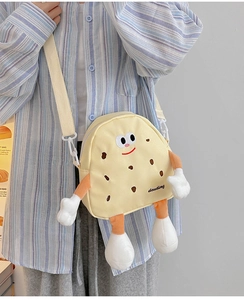 Detail of yellow canvas crossbody bag featuring a cute 3D cartoon biscuit man design