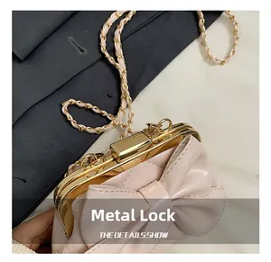 Détail du sac noeud rose clair avec coutures matelassées et fermoir en métal doré