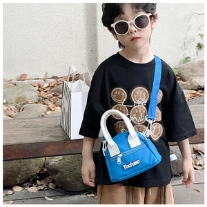 Close-up of royal blue mini kids crossbody bag with white handles and letter logo detail