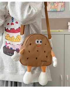 Detail of cute cookie-shaped crossbody bag with embroidered face and adjustable strap