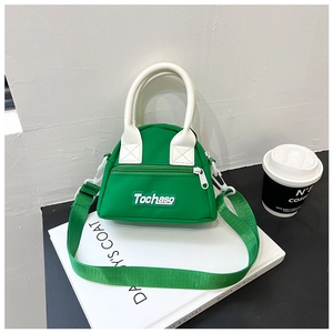 Detailed macro view of vibrant green nylon mini bag with Tochaso logo and white handle