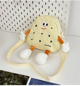 Macro detail of cute biscuit-shaped kids crossbody bag with embroidery and plush limbs