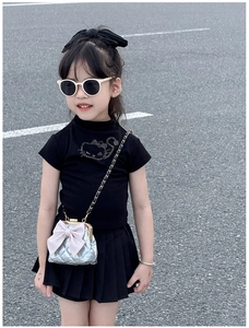 Détail du sac à chaîne matelassé argenté avec nœud rose et tenue d'été pour fille