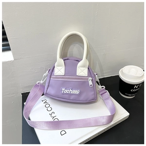Detail of mini purple nylon shoulder bag with white handles and letter patch