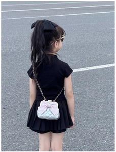 Sac bandoulière argenté matelassé enfant avec nœud rose porté par un mannequin