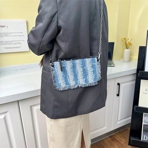 Denim patchwork crossbody bag with blue and white stripes and tassel edge detail