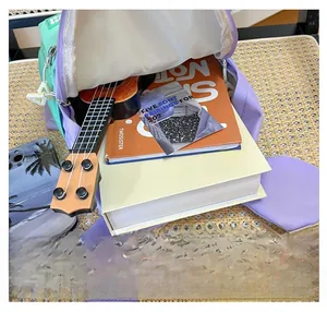Internal capacity view of two-tone children backpack with books and ukulele inside