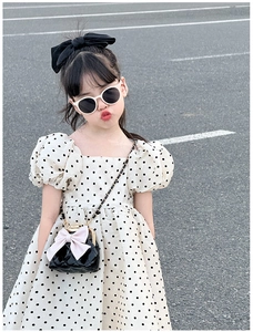 Détail du sac à bandoulière matelassé noir pour fille avec nœud rose et chaîne