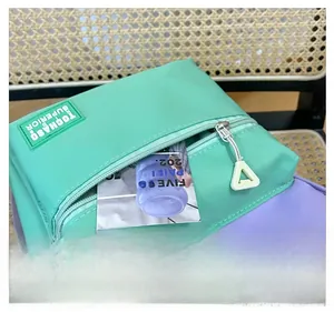 Close-up of mint green and purple children backpack featuring front pocket and logo detail