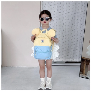 Detailed view of child's backpack featuring blue and yellow color block and cute round ears