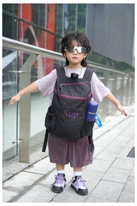 Vue détaillée du sac à dos noir pour enfants avec lettrage violet et poche latérale en filet