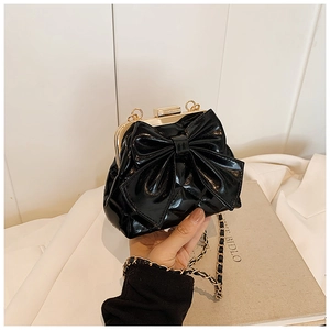 Détail du sac pour filles en cuir verni noir avec grand nœud et fermoir métallique doré