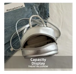 Silver PU leather mini backpack showing internal capacity for phone and wallet