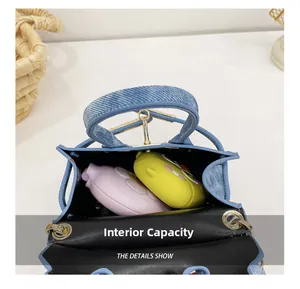 Vue de dessus de l'intérieur du mini sac bleu texture denim avec anneaux métalliques dorés